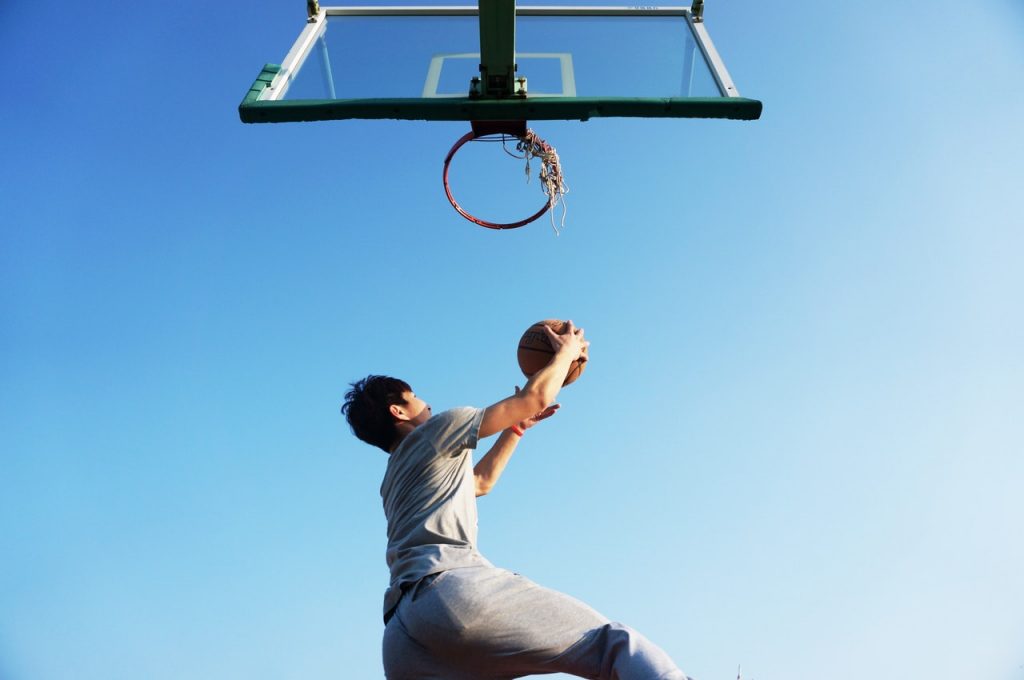 homem fazendo cesta no basquete para ilustrar texto sobre os benefícios do esporte