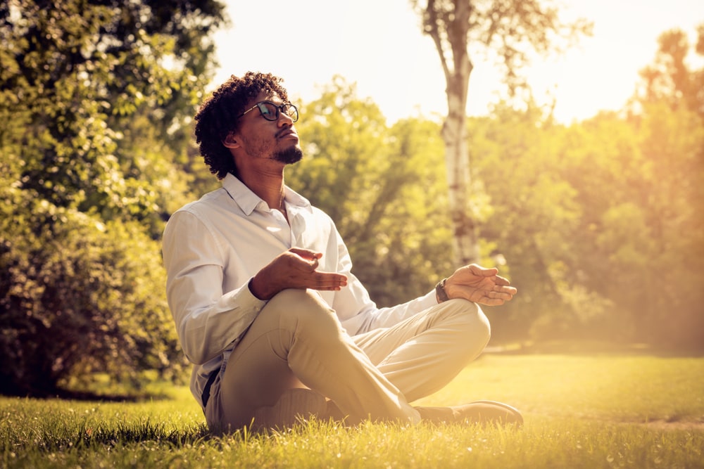 homem sentado na grama para ilustrar texto sobre como cuidar da saúde mental e emocional