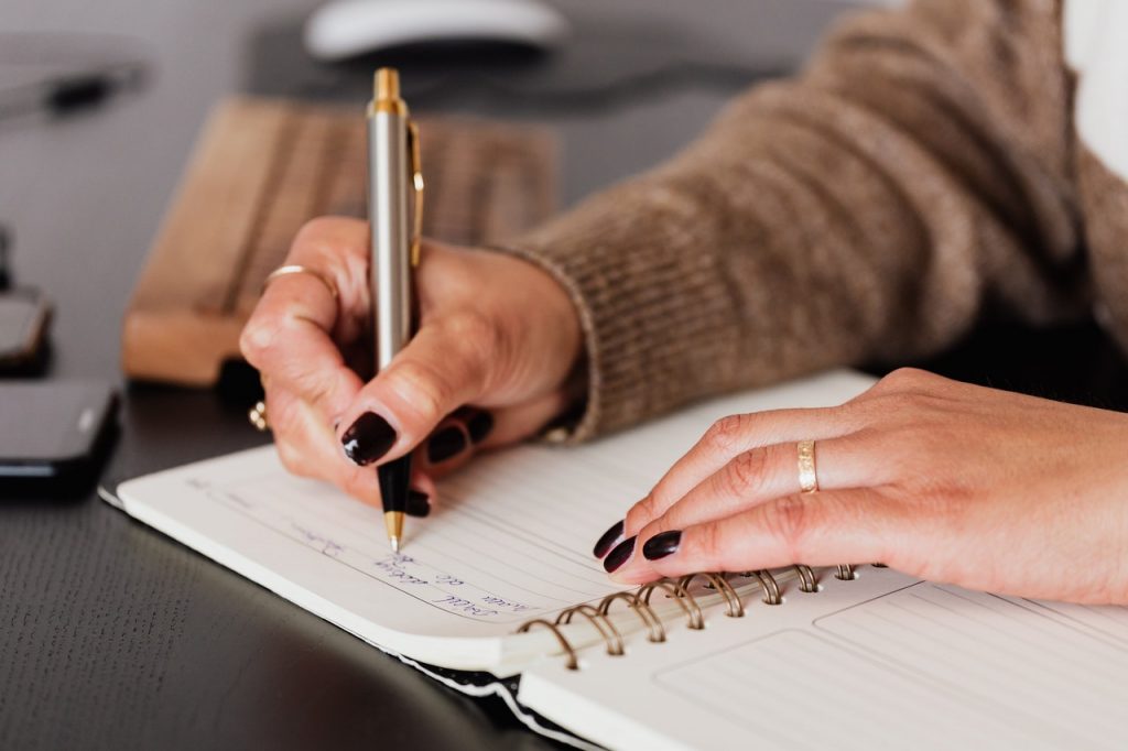 mulher fazendo anotações no caderno para ilustrar texto sobre hábitos de aprendizagem