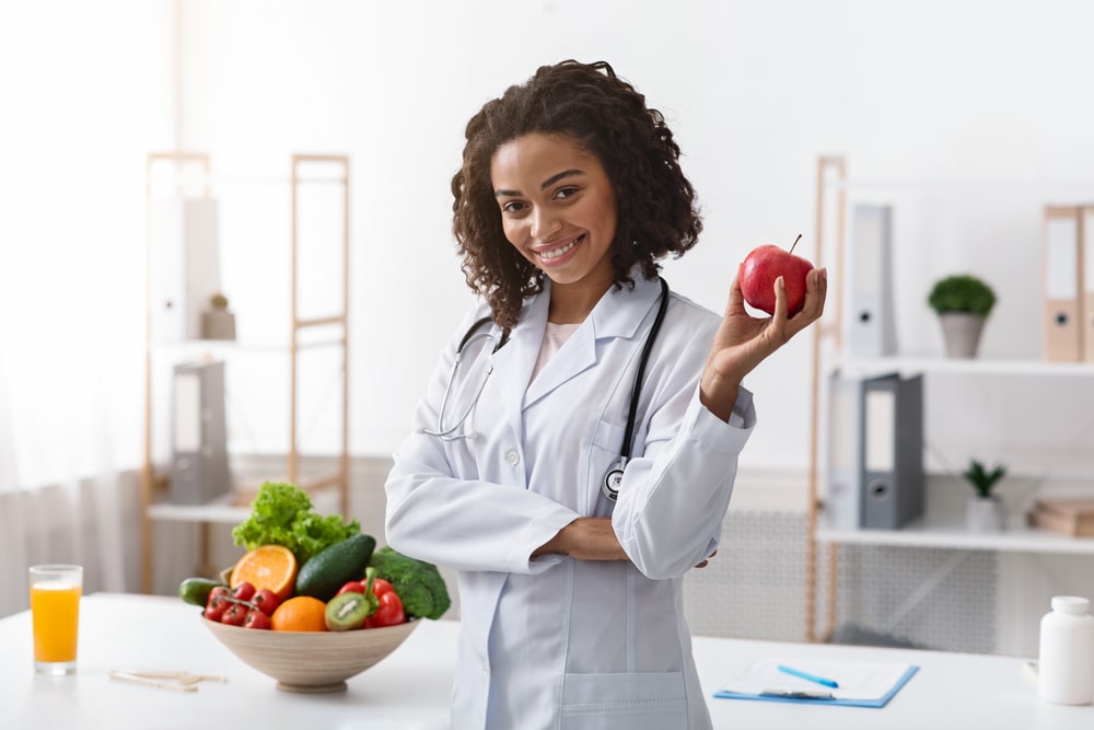 nutricionista com maçã na mão para ilustrar texto sobre pós-graduação em Nutrição