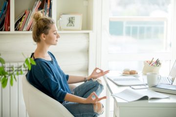 mulher meditando em ambiente de escritório para ilustrar texto sobre equilíbrio emocional no trabalho