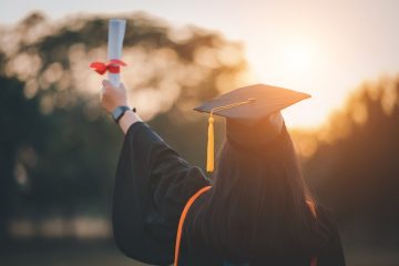 mulher de costas com capelo e diploma na mão para ilustrar texto sobre "posso fazer MBA antes de terminar a graduação"