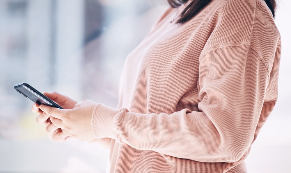 mulher com celular na mão para ilustrar texto sobre velhos hábitos