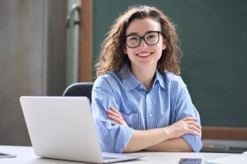 mulher sorrindo com notebook para ilustrar texto sobre pós-graduação em 2023
