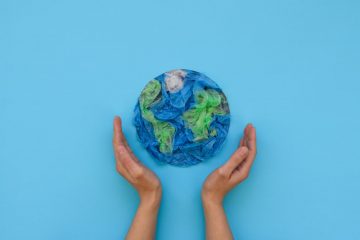 mãos segurando o planeta Terra para ilustrar texto sobre estilo de vida sustentável
