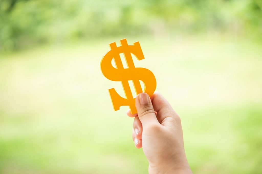 mão segurando símbolo de dinheiro para ilustrar texto sobre qual sua expectativa salarial