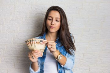 mulher com dinheiro em espécie na mão para ilustrar texto sobre como ganhar mais dinheiro