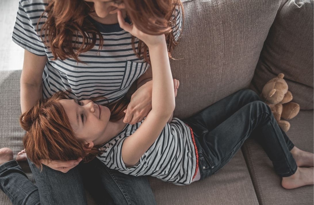 criança fazendo carinho no rosto da mãe