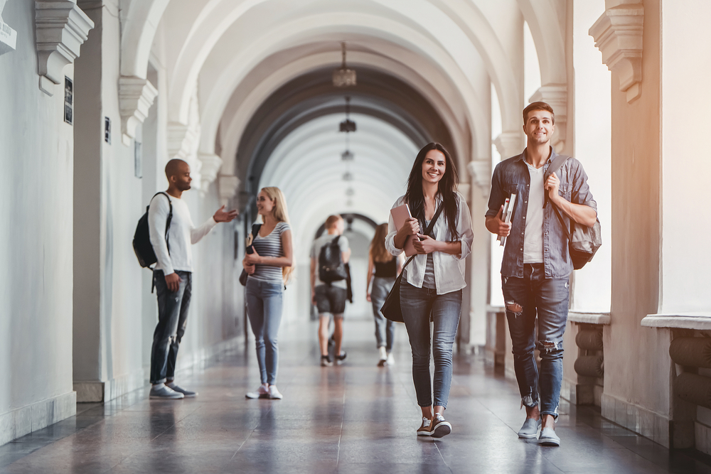 pessoas no corredor de uma universidade para ilustrar texto sobre o que é carreira acadêmica