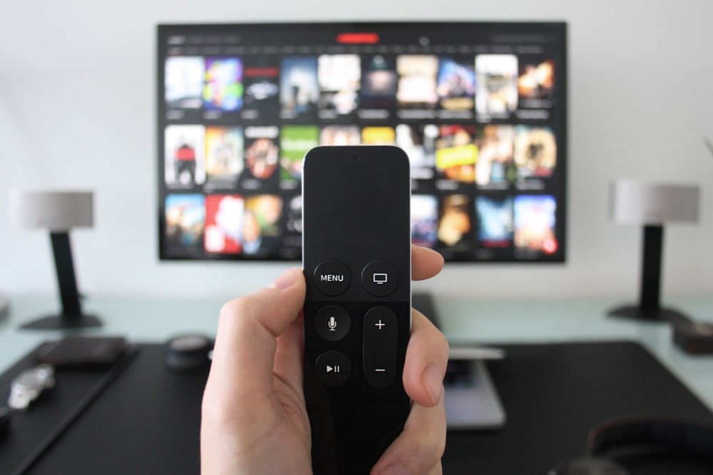 controle remoto com TV de fundo para representar busca por séries