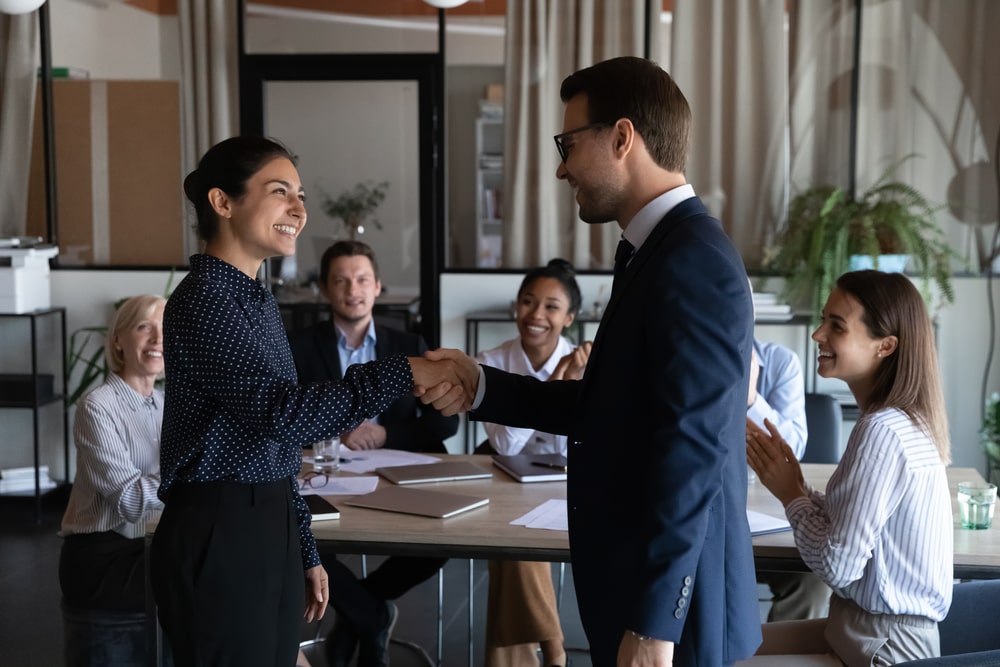 homem e mulher em escritório cumprimentando com as mãos para indicar liderança do futuro