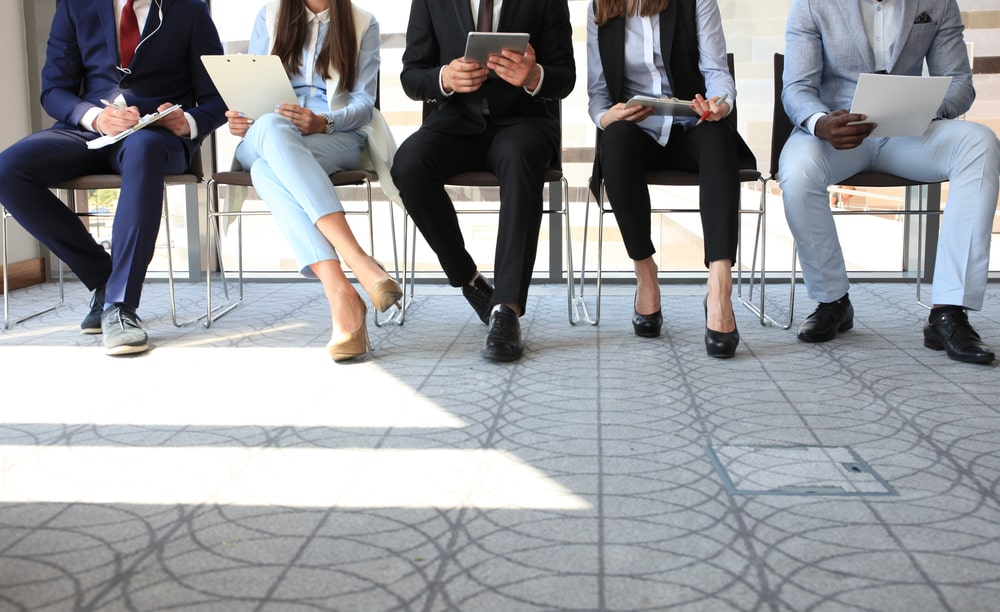 candidatos sentados lado a lado em uma seleção de entrevista de emprego