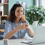 mulher com fone de ouvido na frente do notebook para ilustrar texto sobre tutor online na pós-graduação EAD