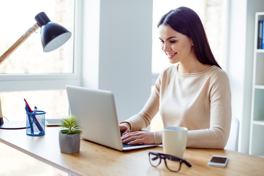 mulher digitando no notebook para ilustrar texto com dicas científicas para escrever artigos de saúde