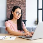 mulher digitando no computador para ilustrar texto sobre significado de versatilidade