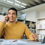 homem ao celular e com notebook para ilustrar texto sobre retorno da empresa quanto ao resultado do processo seletivo