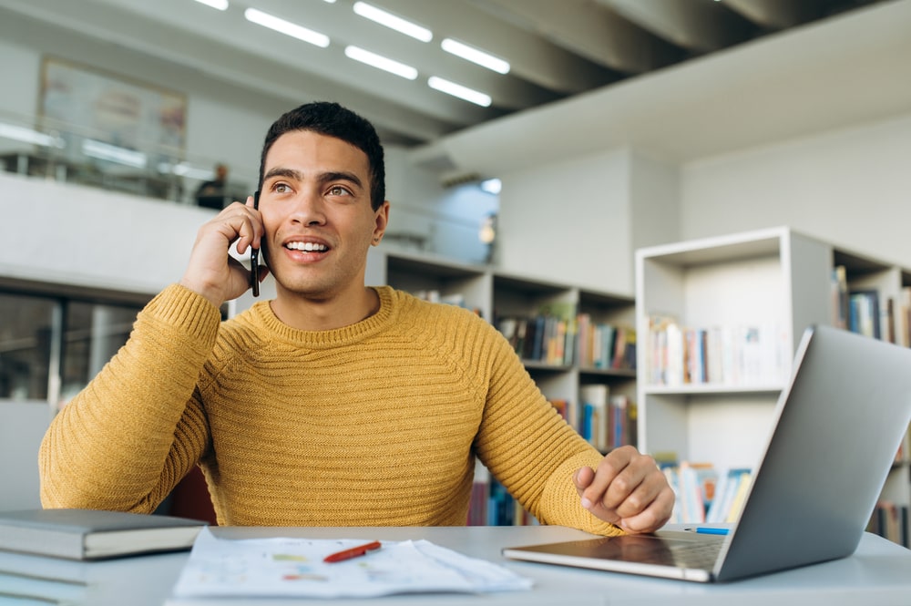 homem ao celular e com notebook para ilustrar texto sobre retorno da empresa quanto ao resultado do processo seletivo