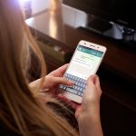 imagem de uma mulher no celular para ilustrar o texto de Como conversar com você mesmo no WhatsApp