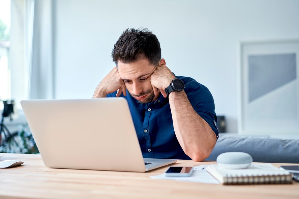 imagem de um homem chateado de frente para o computador para ilustrar o texto de carreira estacionada