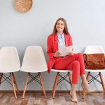 imagem de uma mulher esperando ser entrevistada para ilustrar o texto de como colocar no currículo o emprego atual