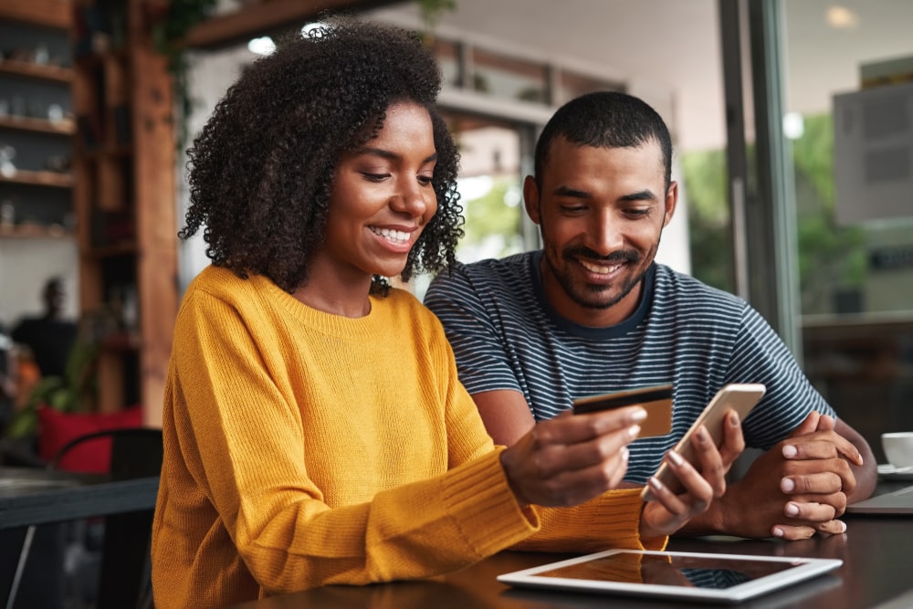 imagem de um casal comprando pelo celular para ilustrar o texto de gatilhos mentais para vendas