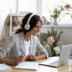 mulher com fone de ouvido estudando no notebook para ilustrar texto sobre cursos de pós-graduação EAD