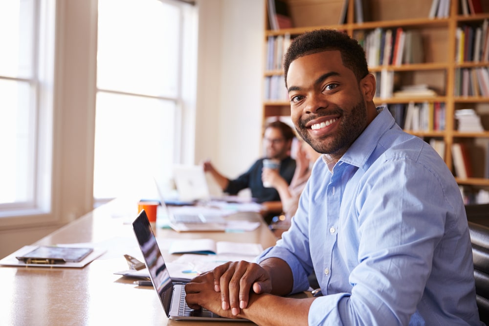 homem sorrindo para ilustrar texto sobre ser importante ter pós-graduação