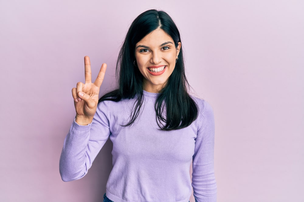 mulher fazendo o número 2 com os dedos para ilustrar texto sobre pós ead na estuda friday