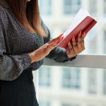 mulher lendo livro para ilustrar texto sobre livros para alavancar a carreira