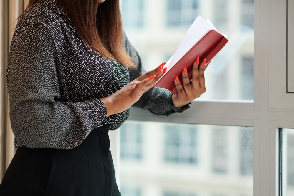 mulher lendo livro para ilustrar texto sobre livros para alavancar a carreira