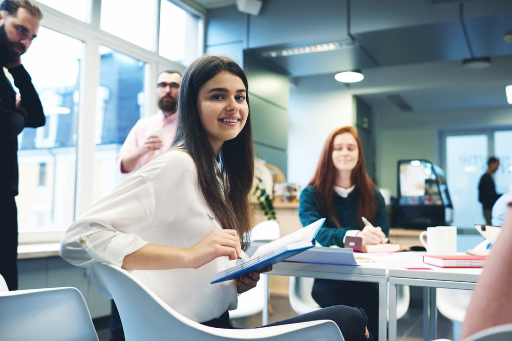 jovem sorrindo para ilustrar texto sobre o que é programa de trainee