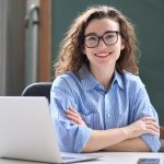 mulher sorrindo com notebook para ilustrar texto sobre pós-graduação em 2023