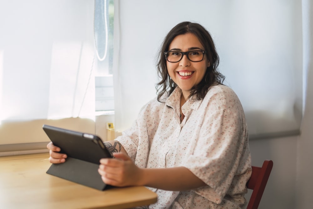 mulher com tablet para ilustrar texto sobre as principais vantagens da educação a distância