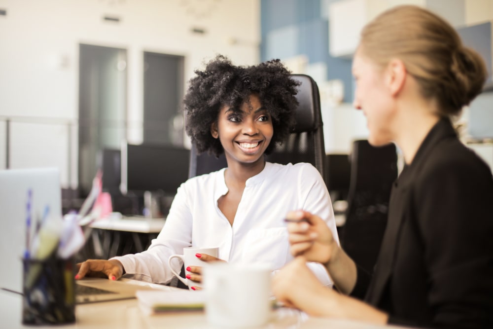 duas mulheres conversando para ilustrar texto sobre bem-estar da equipe