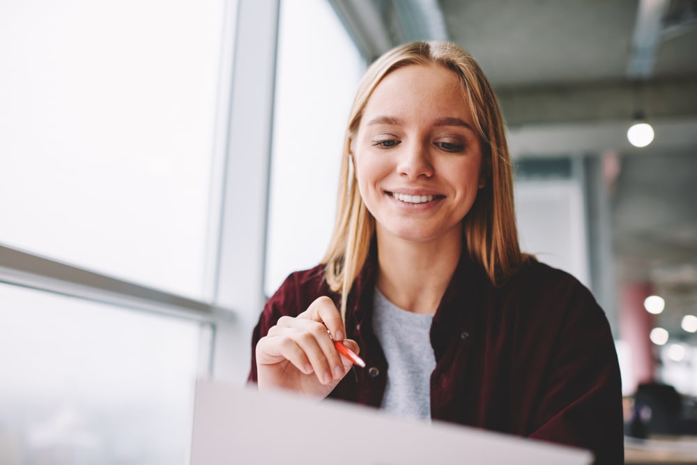 mulher com CV na mão para ilustrar texto sobre como ter um currículo de sucesso