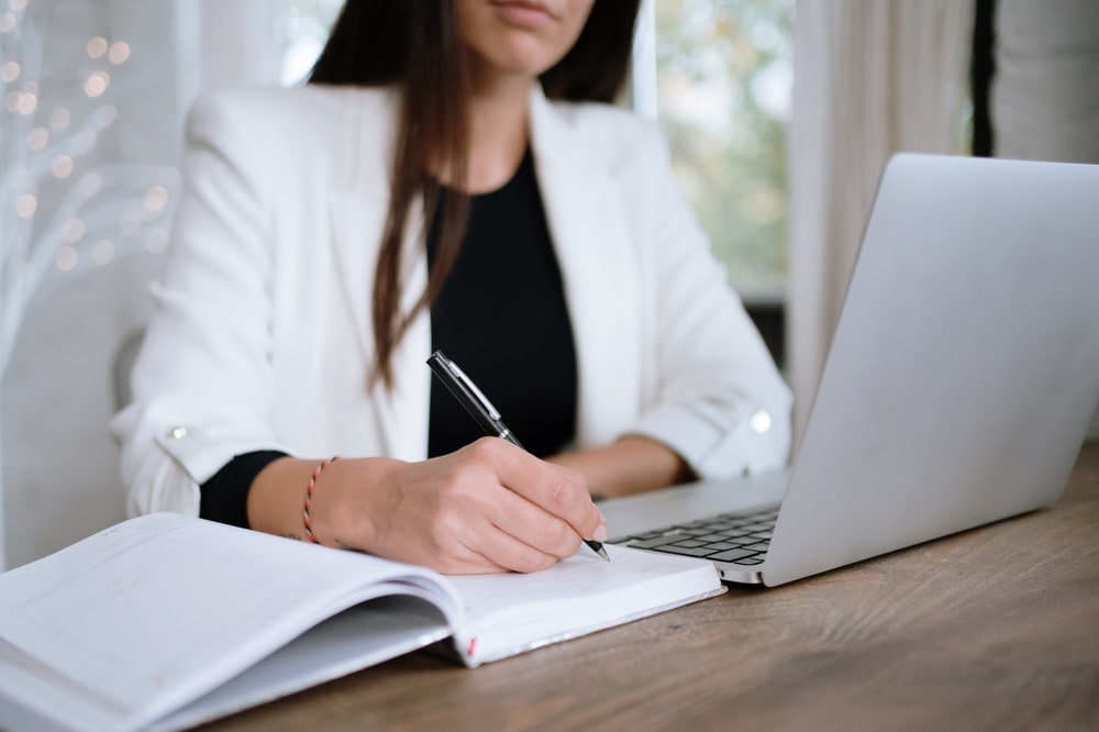 mulher fazendo anotações para ilustrar texto sobre experiência de pós-graduação