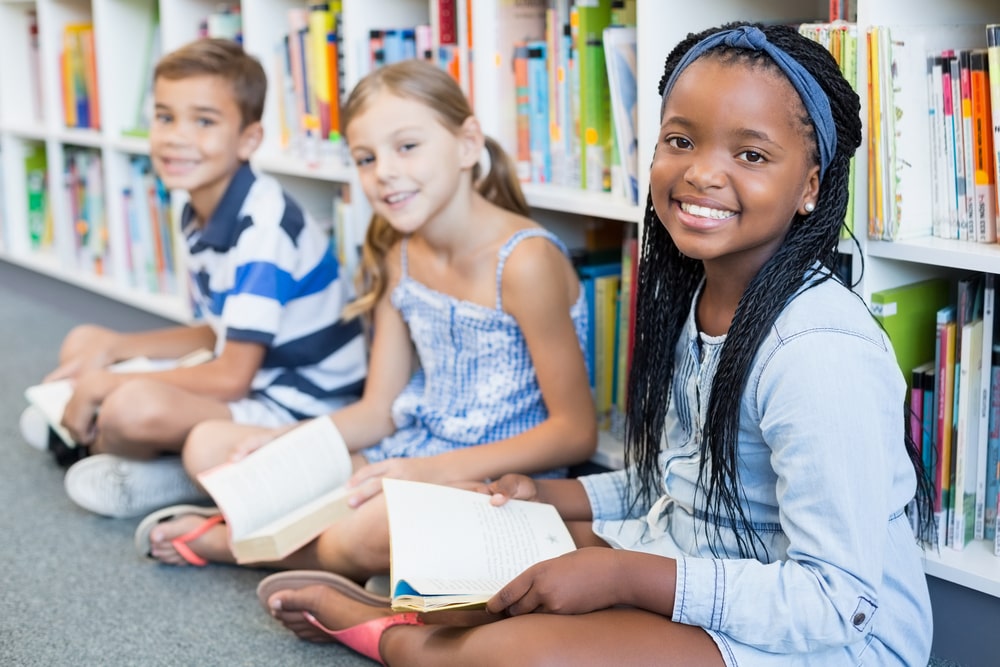 crianças com livros para ilustrar texto sobre incentivo à leitura na Educação Infantil