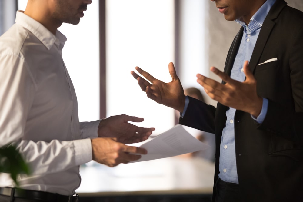 homens conversando para ilustrar texto sobre competição no ambiente de trabalho