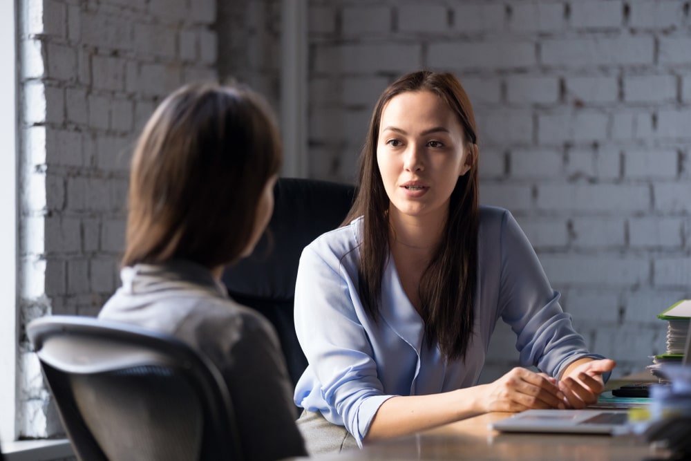 duas pessoas conversando para ilustrar texto sobre modelo de entrevista de desligamento