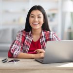 mulher sorrindo para ilustrar texto sobre ser feliz no trabalho