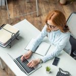 mulher com notebook para ilustrar texto sobre atividades extracurriculares no currículo