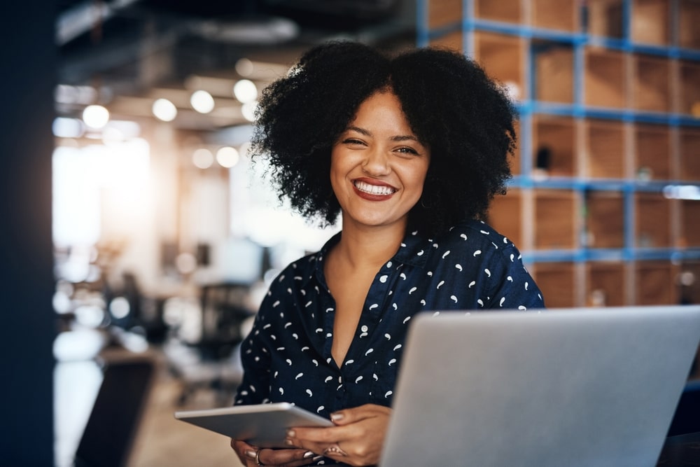 mulher sorrindo para ilustrar texto sobre boas práticas nas empresas para colaboradores