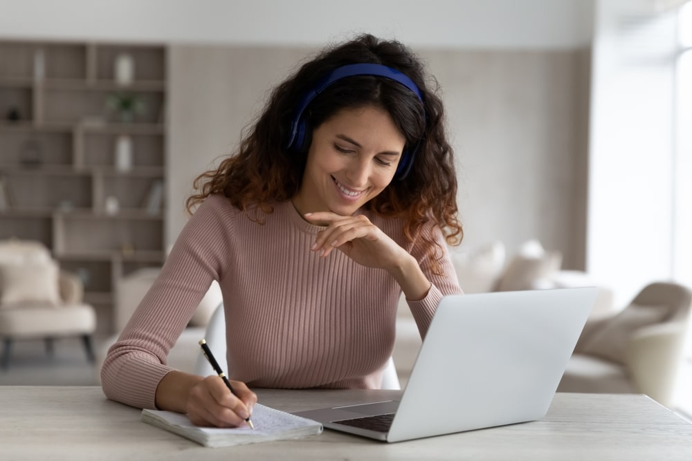 mulher com fone de ouvindo estudando para ilustrar texto sobre estudar ouvindo música é bom