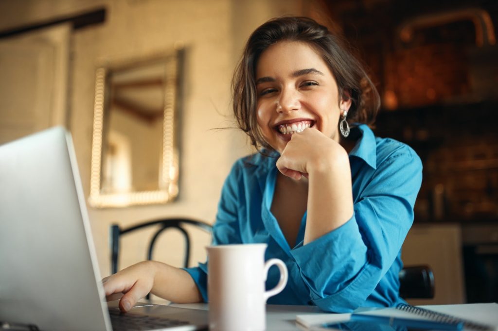 mulher sorrindo com notebook para ilustrar texto sobre acesso vitalício ao curso