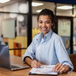 mulher sorrindo no escritório para ilustrar texto sobre talentos qualificados