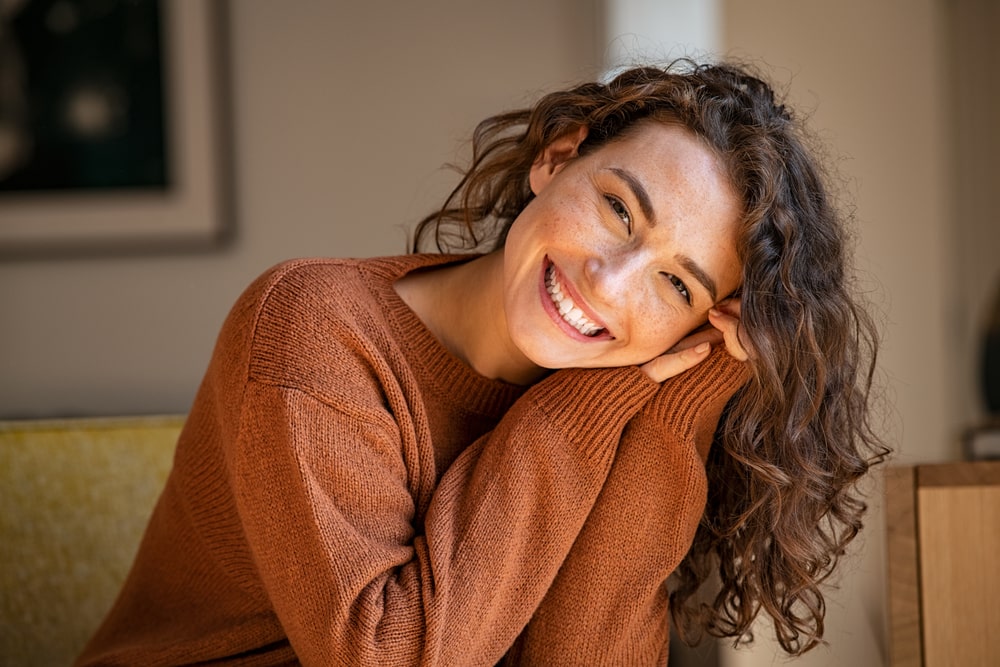 Mulher sorrindo para ilustrar texto sobre exemplos de propósitos pessoais