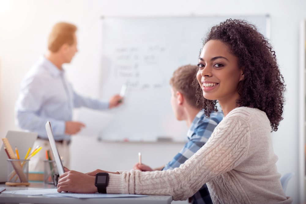 jovem em sala de aula para ilustrar texto sobre o que é estágio remunerado