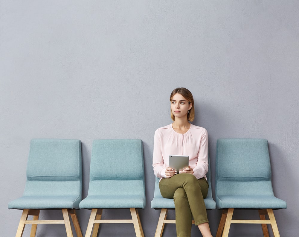 mulher esperando entrevista para ilustrar texto sobre superar obstáculos e rejeições na busca por emprego