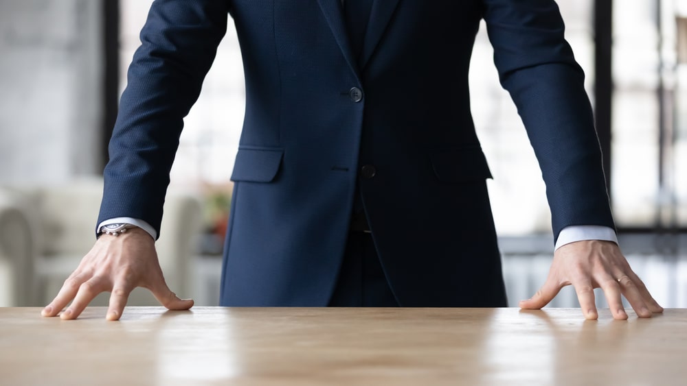 homem com as mãos na mesa para ilustrar texto sobre liderança autocrática