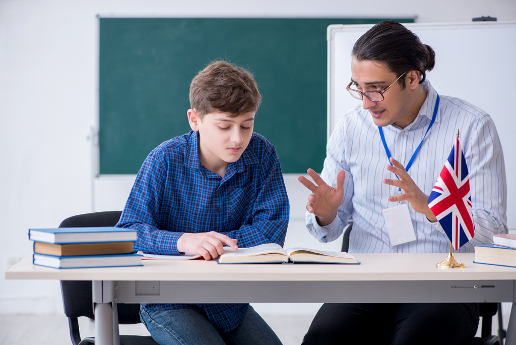 Professor ensinando inglês para criança em sala de aula. 